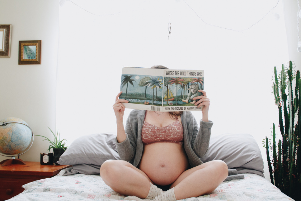 Pregnant Woman in Lingerie Reading a Magazine on the Bed